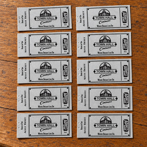 Ten older silver Town Hall Cinemas Adult vouchers laid naturally on a wooden table